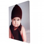 Einen Foto Leinwand mit einem Portraitfoto eines Baby mit Mütze