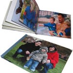 Ein Fotobuch aufgeschlagen mit zwei Fotos von einer Familie.