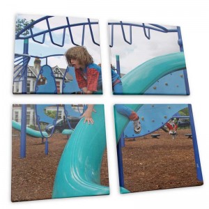 Eine vierteilige Leinwand mit einem Foto von einem Jungen auf einem Spielplatz