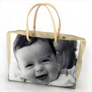 Eine Handtasche aus Leder in beige mit einem Foto eines babys in schwarz/weiss