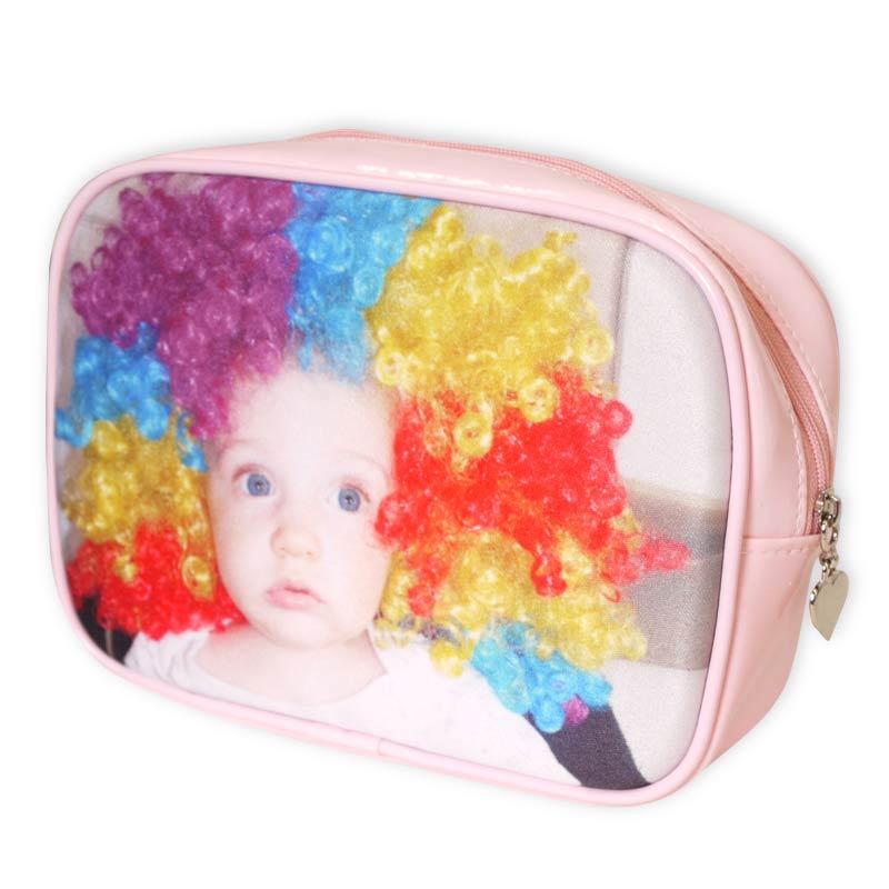 Eine Schminktasche ihn rosa mit einem Foto eines babys mit bunter Perücke